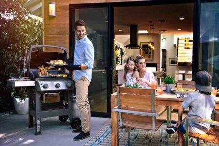 Weber® Spirit II™ E-310 Premium Gas BBQ man grilling outdoors with Family